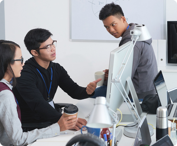 AI Collections Coach - Three people collaborating around computer monitor