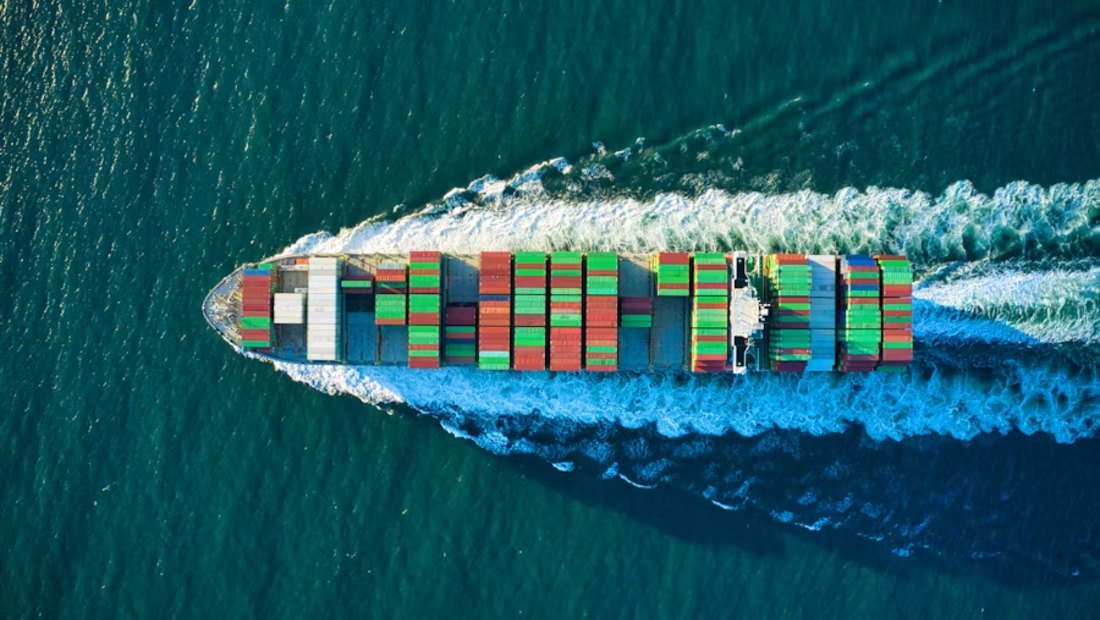 Loaded container ship cutting through open water