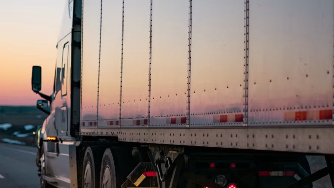 Articulated truck on the road at dusk