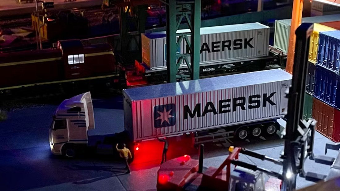Containers transferring between rail and road at an intermodal terminal at night