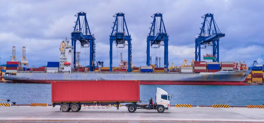 Container ship at a quay with a truck collecting alongside