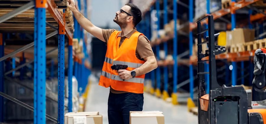 Warehouse operative scanning stock in a racking aisle